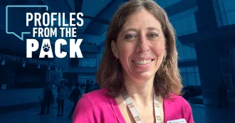 Shalako Thomas in bright pink shirt in front of a Madison College photo of windows in Gateway entrance of the Truax Campus.