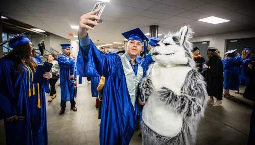 2024 Madison College graduate takes a selfie with Wolfie
