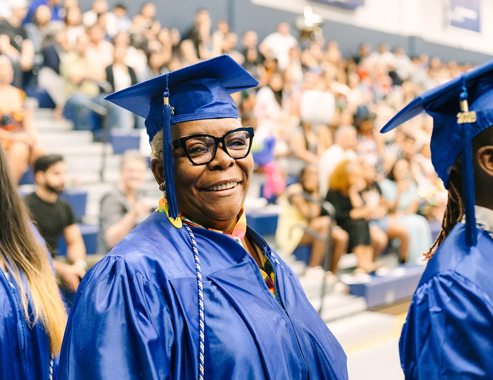 Madison College High School Completion Program graduates smiling toward camera at graduation ceremony.