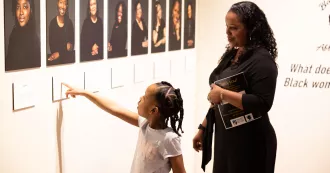 A young girl points to a photo in the BWAG gallery
