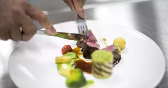Person cuts meat with knife and fork. 