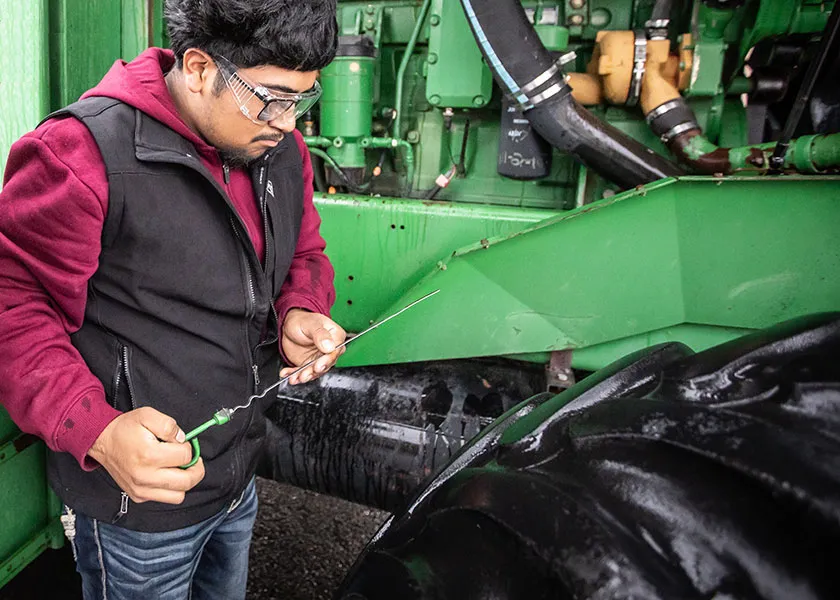 Ag Tech student performing maintenance checks on a tractor