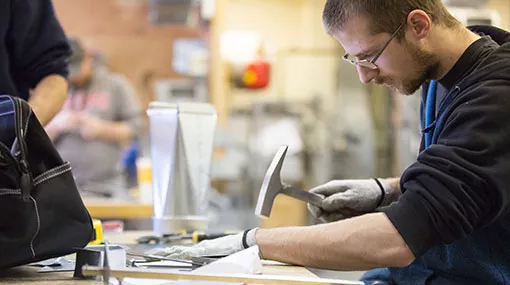 Madison College student fabricating sheet metal
