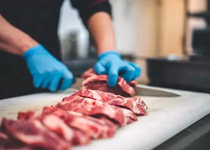 two hands cutting meat