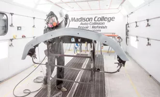 auto collision student painting a car part