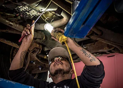 Automotive Technology student inspecting a car's chassis