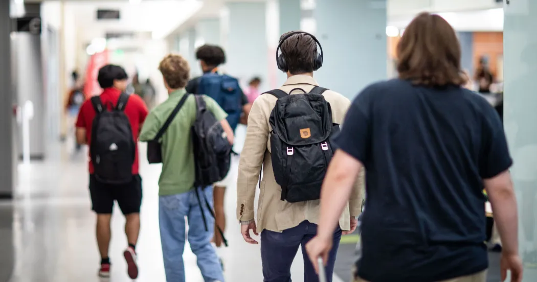 Students walking in the hallway at the Truax campus with their backs to camera.