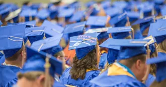 Photo of Madison College students at graduation ceremony with back view of their caps. 