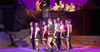 Photo of Cabaret actors on stage in costumes.