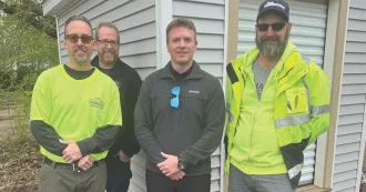 Madison College students and staff and Department of Corrections staff stand in front of a donated shed.