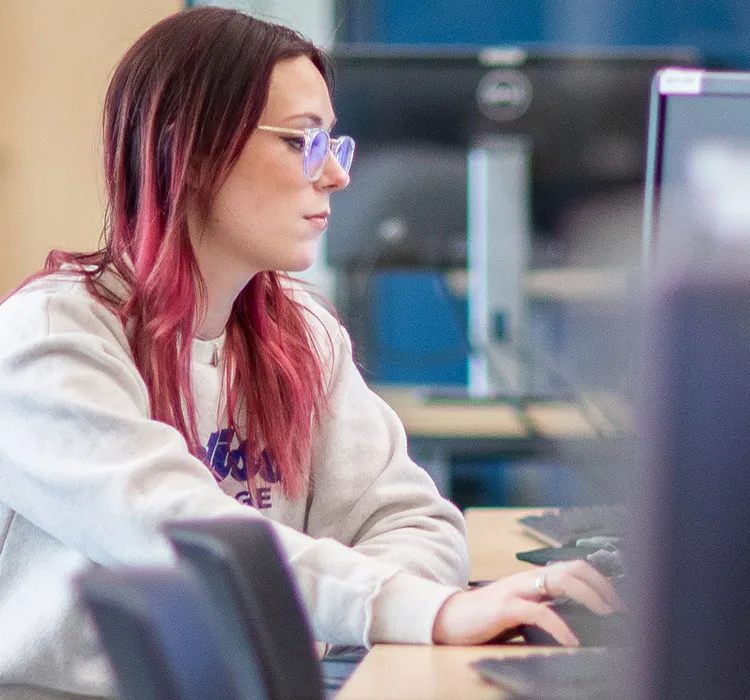 Emily, a Madison College cybersecurity student working in the IT lab space