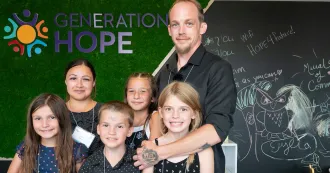 Generation Hope logo on wall with family posing in front of it