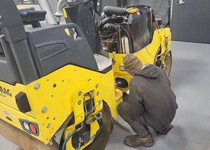 Person repairing heavy equipment
