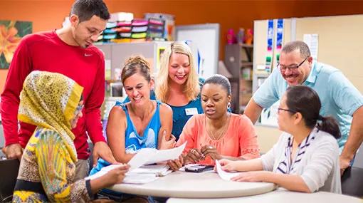 Diverse group of students and staff working together at a round table