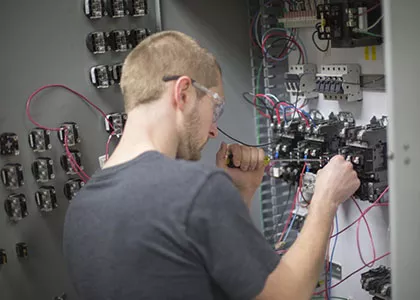 electricity diploma student work on an electrical panel