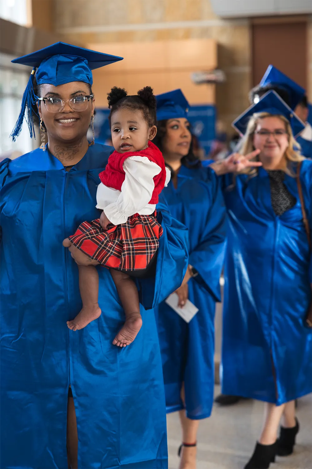 Female graduate holding her baby daughter