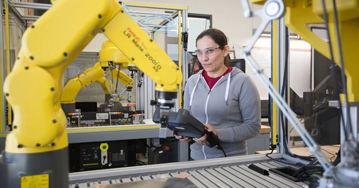 Electro-Mechanical Technology student working with a robot