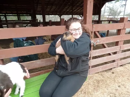 Kailyn Ripp hugs a baby goat.