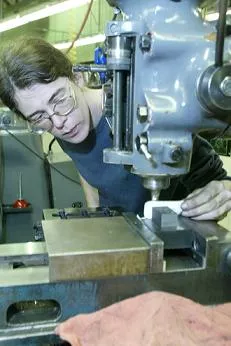 A machinist student using a machine.