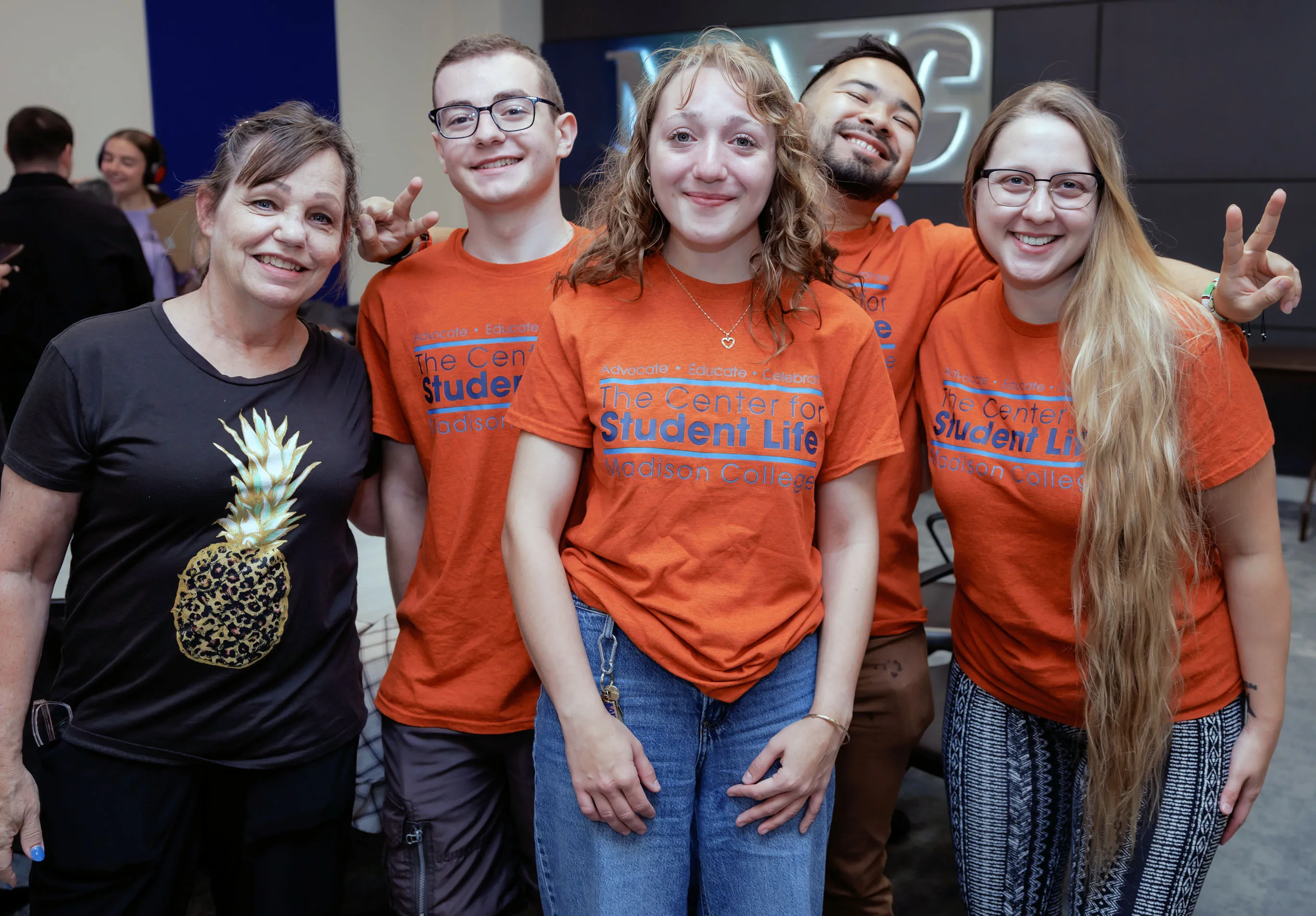 Students at the Madison College Voting Summit posing for a picture wearing matching orange T-shirts.