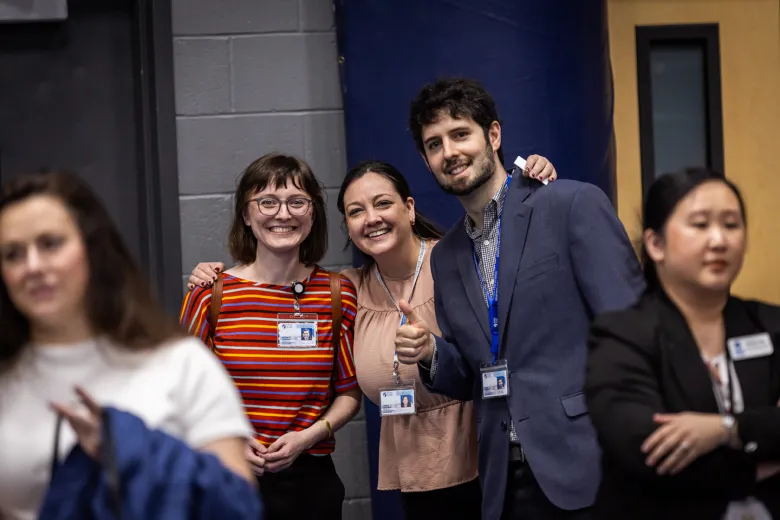 Three people smiling and looking at the camera