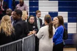 A group of people talking around a metal fence