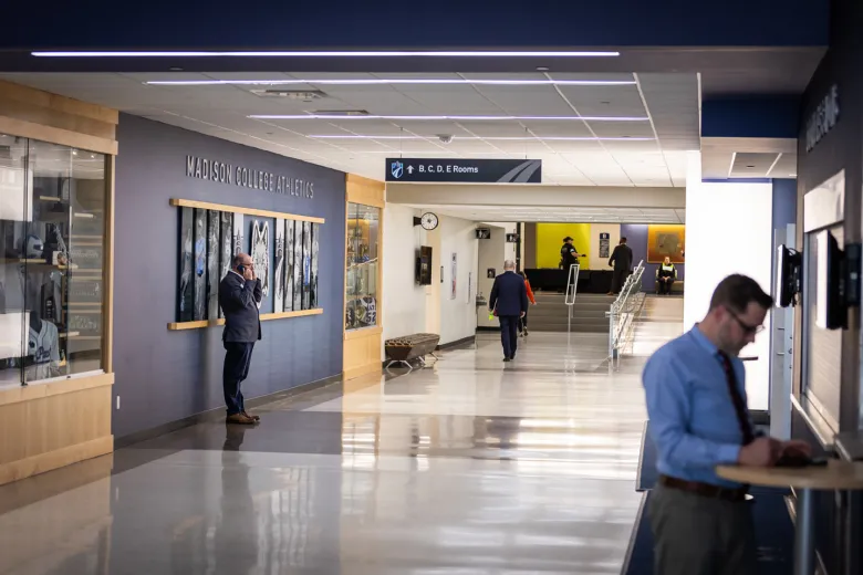hallway with blue, white and wood walls. Person on cell phone.