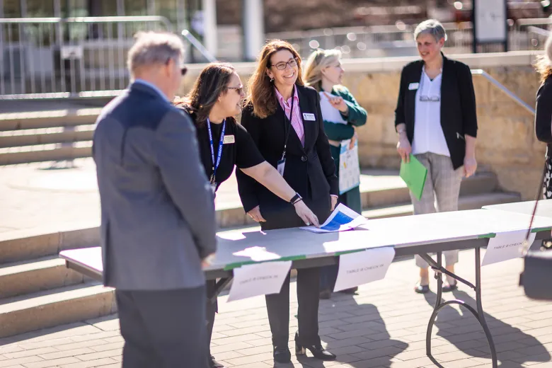People standing outside next to a folding table.