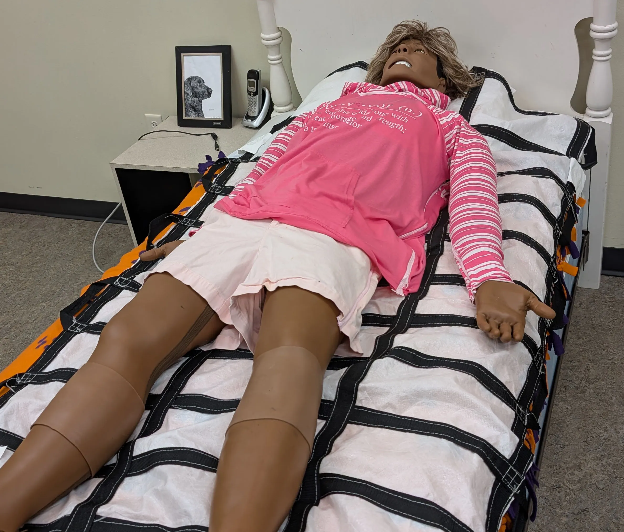 EMS manikin dressed in a pink hoodie and shorts.