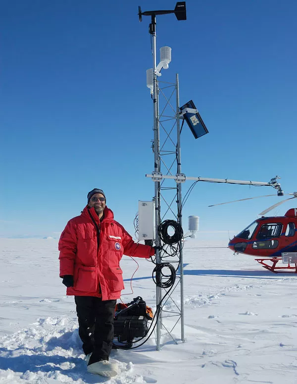 Madison College atmospheric science instructor at an Automated Weather Station (AWS) in Antarctica.