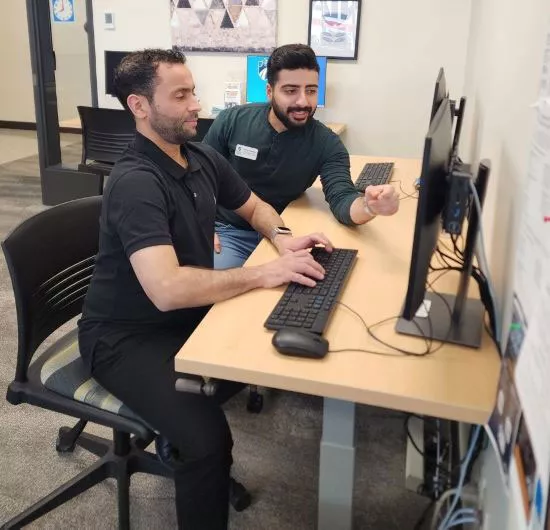 Hussein Alshammari, a student support specialist for Madison College’s School of Academic Advancement, guides a student through the student enrollment process.