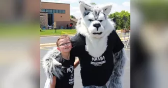 Madison College Wolfie poses with child at 2024 Metal Mania