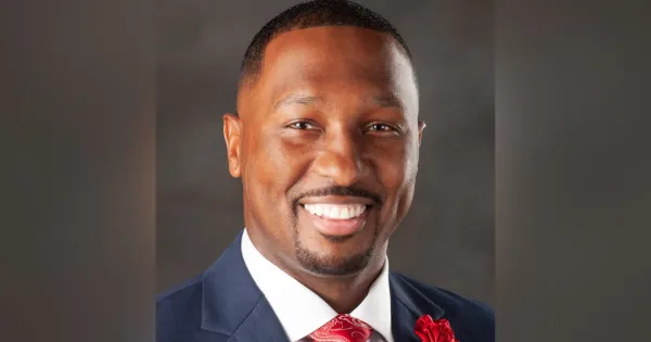 Close up headshot of Donald Dantzler, wearing a blue blazer, red tie. 