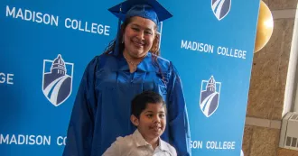 A Madison College grad posing with her child.