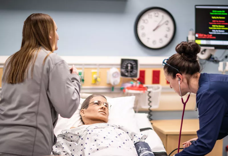 nursing students practicing on a medical mannequin