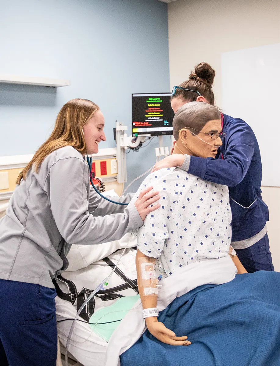 Two nursing students interacting with mannikin
