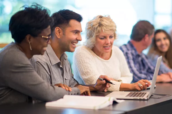adult students at a table in conversation