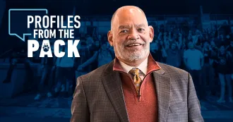 President Daniels with the Profiles the Pack logo behind him.