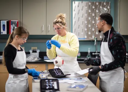 three students studying around lab table