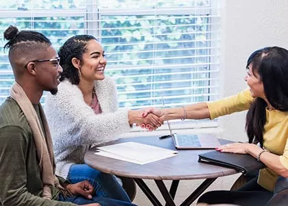 three students seated having a mock real estate meeting
