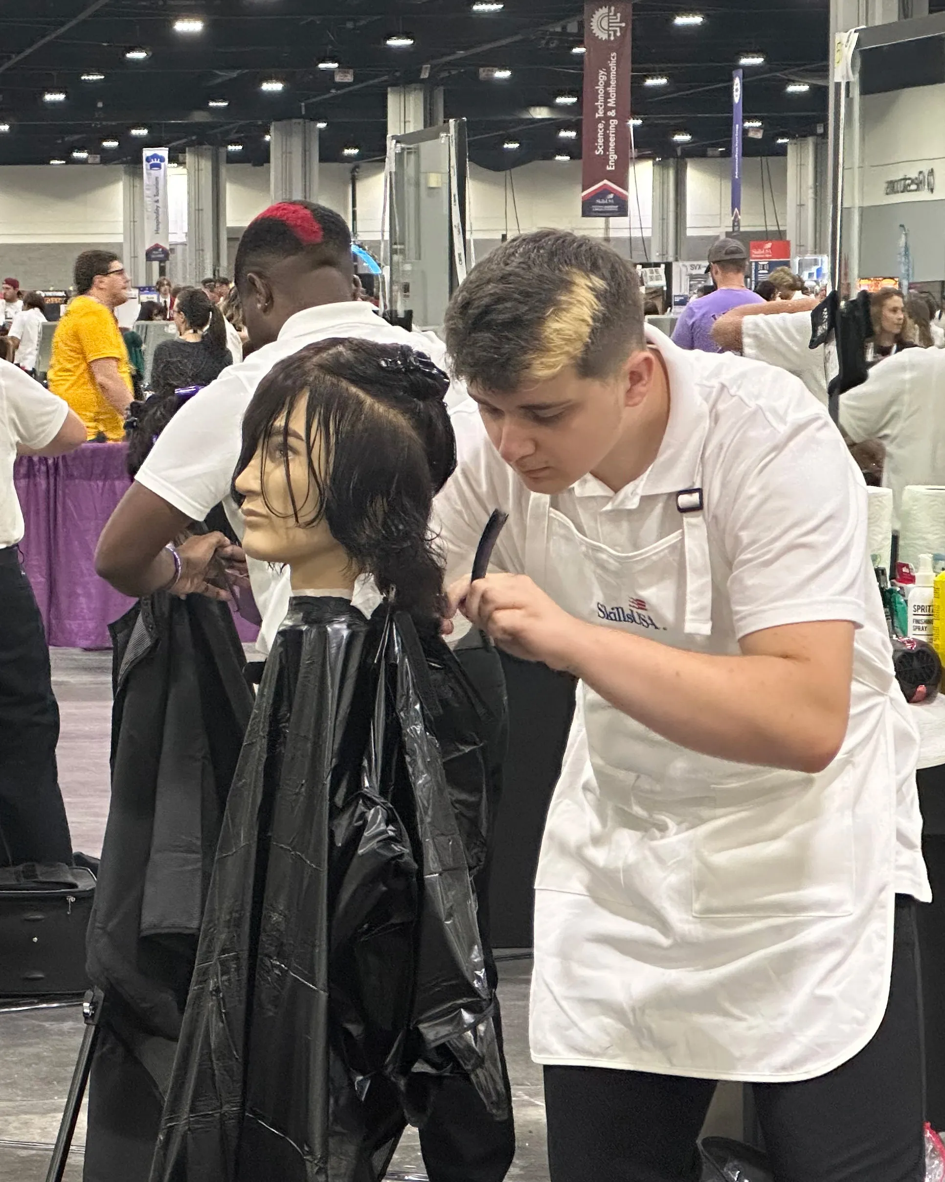 student stying a mannequin's hair