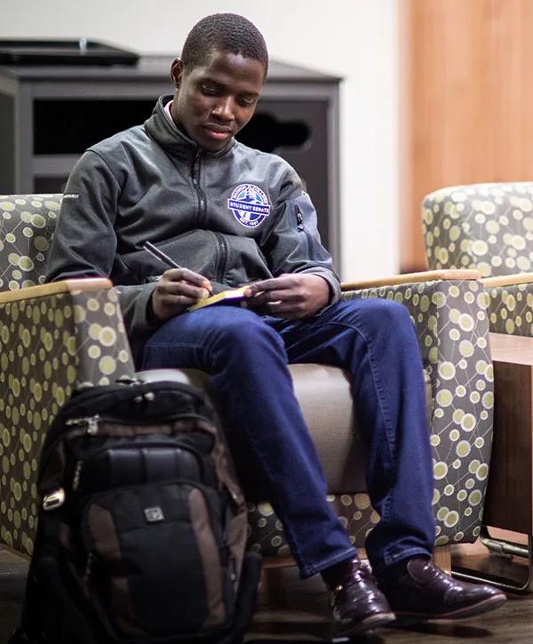 Madison College student senate member writing notes on a legal pad