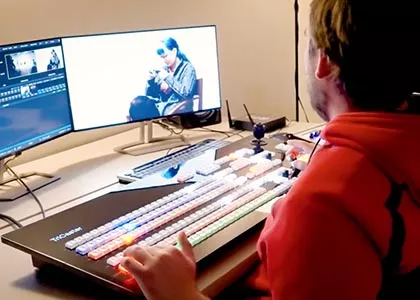 student typing on a tricaster looking at dual monitors