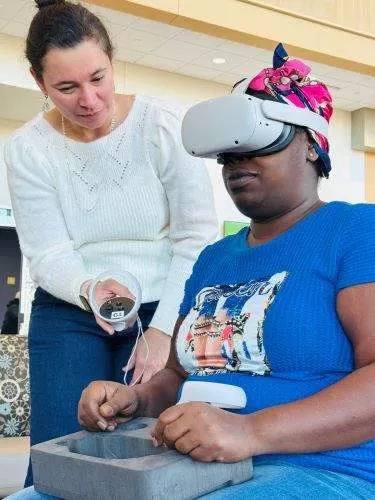 Spanish instructor Carolina Bailey helps a student with the VR headset.