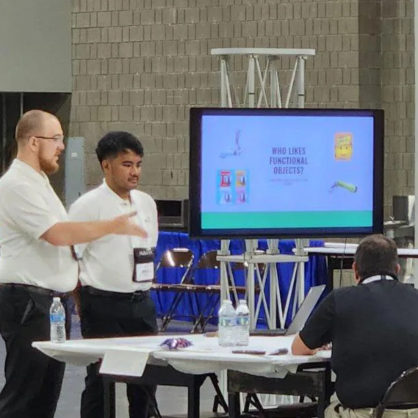 two students presenting their skillsusa project on a screen. Screen says "who likes functional objects?"