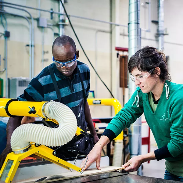 student using a table saw in a woods class